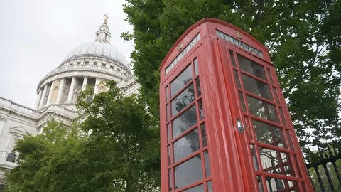 A view of a red telephone booth with the St. Paul's cathedral in the background. Stock Footage 107952259