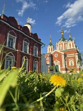 A view of the red Temple from below, with green grass and daisies in Kolomna. Stock Photos
