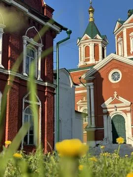 A view of the red Temple from below, with green grass and daisies in Kolomna. Stock Photos