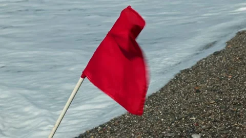 View of red warning flag on pebble beach with storm waves on Cretan Sea coast. Stock Footage 340072532