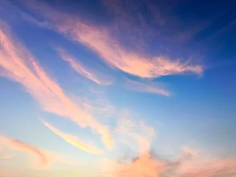 A view of reddish clouds as the sun rises over a dense urban area. Fotos Stock