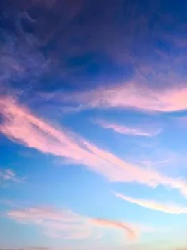 A view of reddish clouds as the sun rises over a dense urban area. Stock Photos