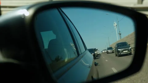 View from the reflection of the side mirror. Cars are driving on the road Stock Footage 240858227