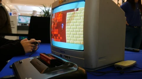 View on a retro game console game played on an old tv in a game exhibition event Stock Footage 106106010