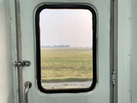View of the rice fields from the box window at the train door Stock Photos