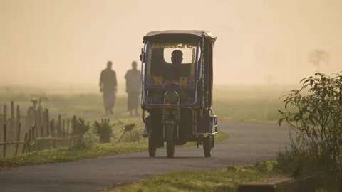 View of a rickshaw driving on a rural road in Bogura, Bangladesh. Stock Footage 335592243