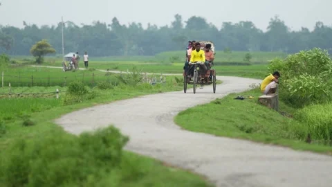 View of a rickshaw on a winding rural road in Bogura, Bangladesh. Video stock 334971292