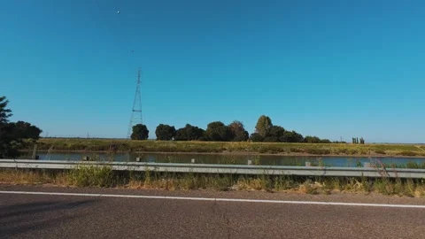 View of river and power lines while driving on a levee in the california delta i Stock Footage 313578322