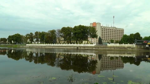 View of river and trees in city park during overcast weather Видео 340447956
