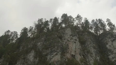 View of river bank with sheer cliffs over river. Panoramic view from floating Stock Footage 121774853