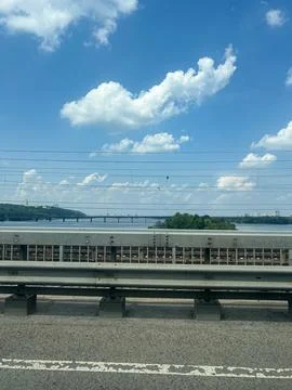 View of a River Bridge and Power Lines on a Sunny Day Stock Photos