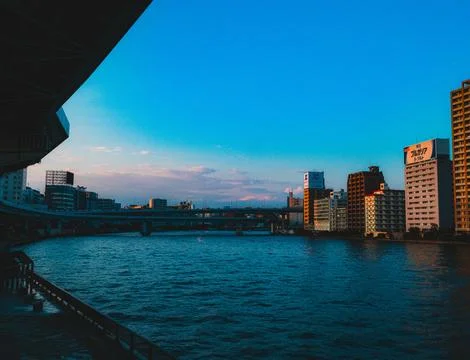 A view of a river with a bridge in the background Stock Photos
