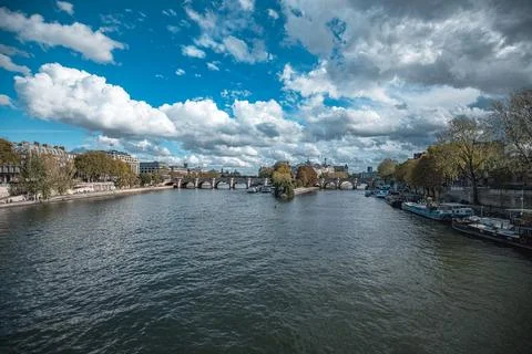 A view of a river with a bridge crossing it in the middle distance. Buildings Stock Photos