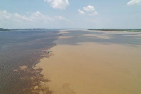 View of river confluence showing distinct water color differences in Amazon Stock Photos