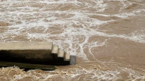 View of a river dam during a flood with brown water Stock Footage 321320440