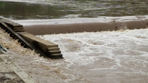 View of a river dam during a flood with brown water Stock Footage 321320443
