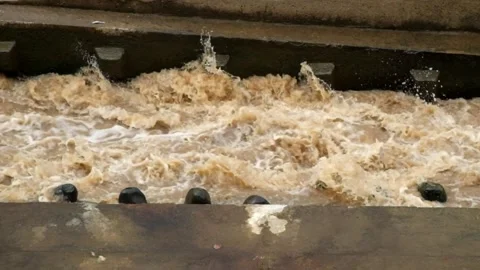 View of a river dam during a flood with brown water Stock Footage 321320446