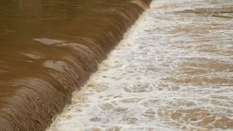 View of a river dam during a flood with brown water Stock Footage 321320487