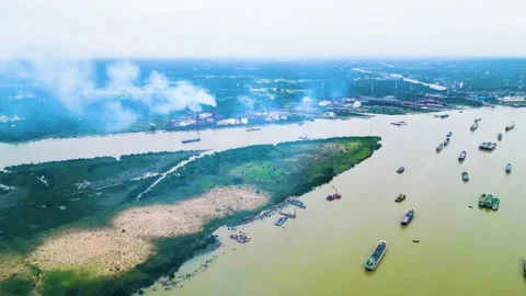 A view of a river featuring small cargo ships navigating the water, alongside a  Stock Footage 287771534