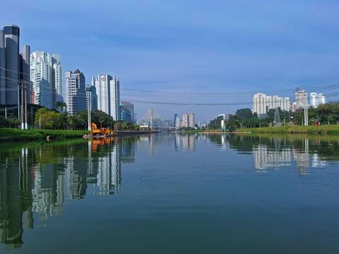 View of the river, flanked by trees and buildings. Stock Photos