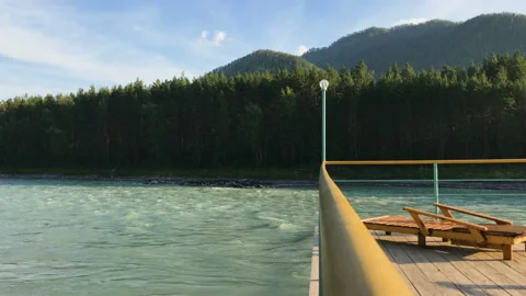 A view of a river, a forest and mountains from a peer railing Stock Footage 92844585