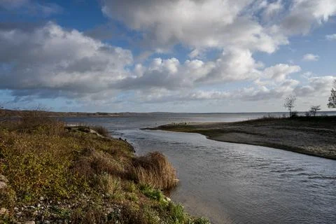 A view of a river outlet from a lake with a dramatic sky in the background Foto stock