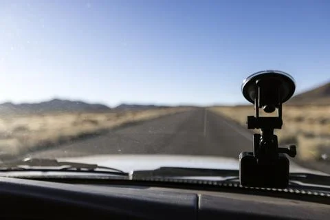 View of the road ahead through a windshield next to an action camera with the Stock Photos