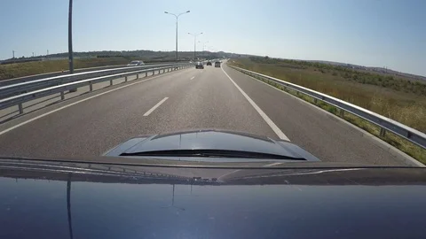 View of road on Crimean bridge from moving blue car. Go pro is on roof of Stock Footage 124573752