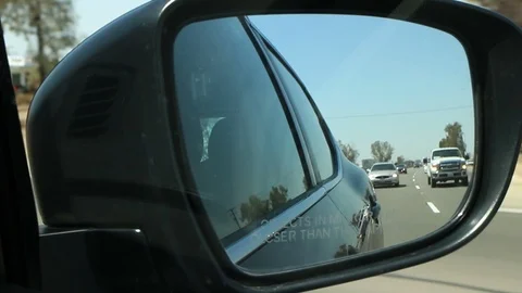 View of the road in the rearview mirror of a car at sun. Video stock 97380196