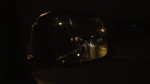 View of the road in the rearview mirror at night Stock Footage 105259646