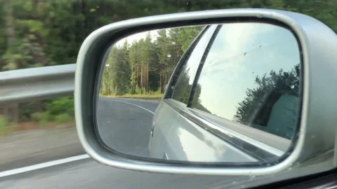 View of the road in the side mirror of the car while driving,  summer weather Stock Footage 124791686