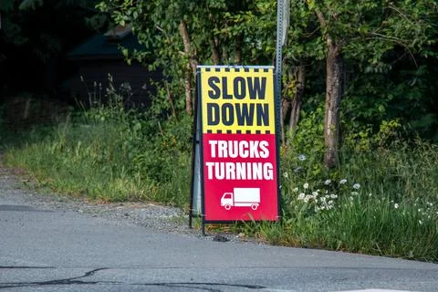 View of road sign Slow Down Trucks Turning in Whistler Stock Photos