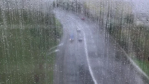 View of the road through a wet window with drops, during the rain with the Stock Footage 143211442