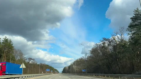 View of the road through the window of the car moving on highway among trees in Stock Footage 234834390