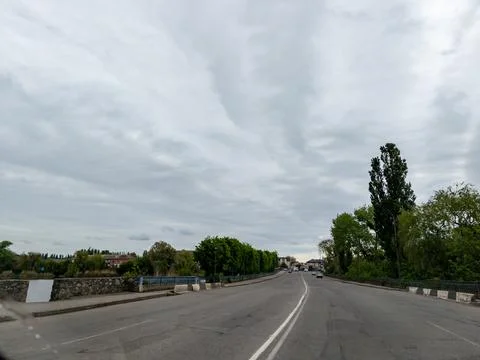 A view of a road with trees and a cloudy sky Stock Photos