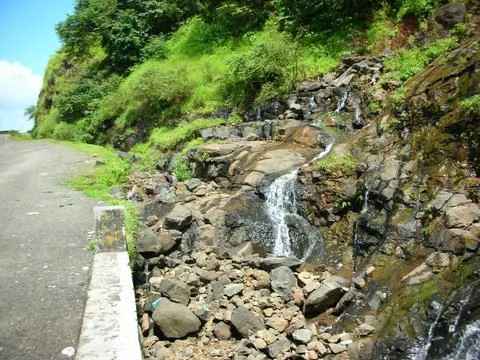 View of a roadside waterfall during a road trip Stock Photos