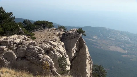 View of rock hanging over precipice of Mount Ai-Petri and on coast Black sea. Stock Footage 106774906