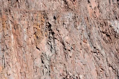View on a rock wall of open pit mine. porphyry rocks Stock Photos