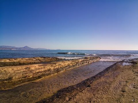 View of rocks on the beach with waves in Cabo Huertas beach in the province o Stock Photos