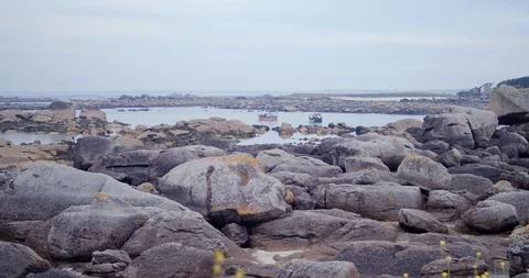 View of a rocky Atlantic coast with two fishing boats and slowly moving flowers Stock-Footage 112702932
