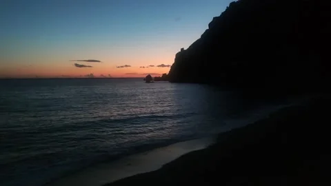 View of the Rocky Coast Next to the Cliff With Dark Ocean Water During Sunset.  Stock Footage 202340325