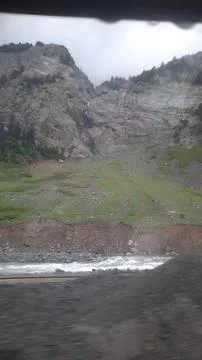 A view of a rocky mountain with a waterfall Stock Photos