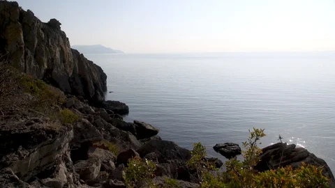 View of  rocky seashore along Galitsyn trail. Sea sparkles in rays of sun. Stock Footage 108429370