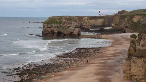 View of a Rocky Seashore With a Lighthouse (Marsden Beach, England) Stock Footage 246941126