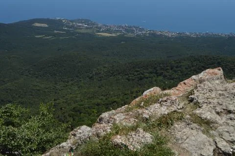 THE VIEW FROM THE ROCKY TOP OF THE MOUNTAIN TO THE PINE FOREST AND THE SEASID Foto stock