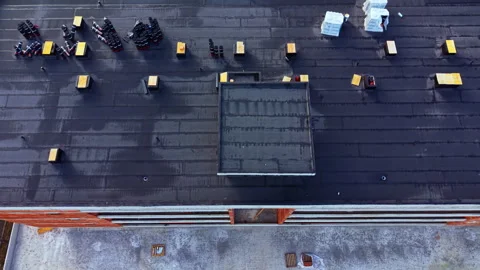 View of a rooftop construction site showing building materials and tools being Stock Footage 332031682
