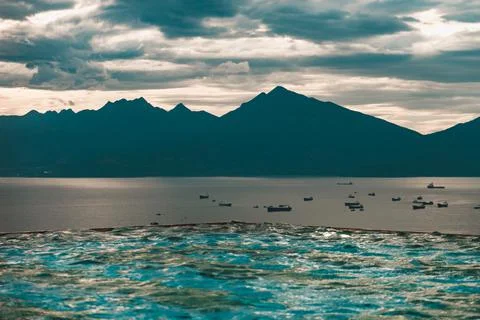 View from the rooftop pool to the ocean and mountains in Asia. Stock Photos