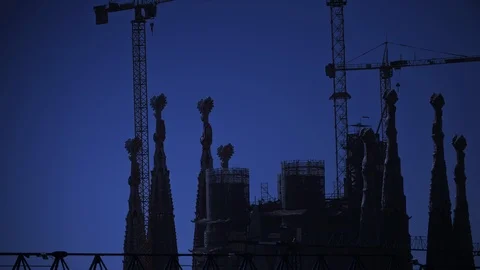 View of rooftops, action cranes, blue sky and silhouette of Sagrada Familia. Stock Footage 98764372