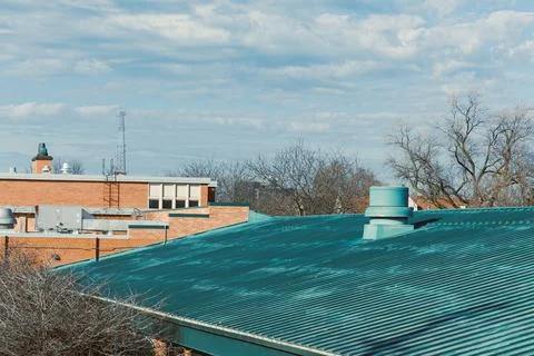 View of rooftops and trees under a sky filled with clouds during a clear da.. Stock Photos