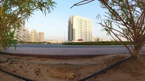 View of a roundabout from ground level framed by green bushes. Concept of urb Stock Footage 139027506